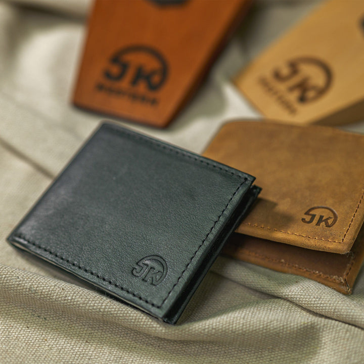 Black leather wallet closed on table with a brown leather wallet