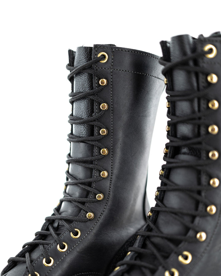 close up of the Fire Inlander - Black showing the gold eyelets and hooks in contrast to the black leather.